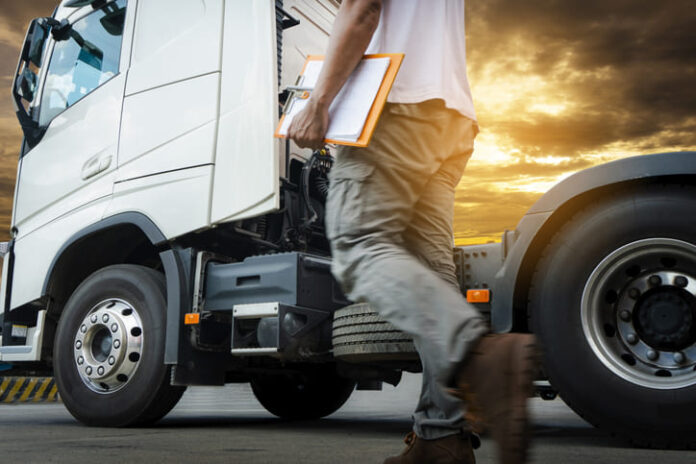 Truck transportation, truck driver walking around semi truck inspecting and safety check before driving a truck