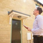 Male real estate agent looking up at a house exterior