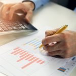 office clerk working with statistical reports and entering data into a computer