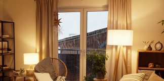 View of a warm light cozy living room in winter with a snowstorm outside