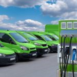 Electric vehicles charging station on a background of a row of vans