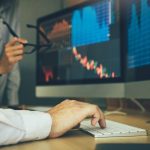 Two business stock brokers stress and looking at monitors displaying financial information