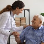 Thankful mature sick man holding nurse hand appreciating for help