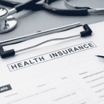 Health Insurance form and stethoscope on desk