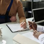 Close up of man filling in medical insurance form