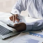 Businessman using a calculator to calculate the company's financial results in the office and tax, accounting, statistics and financial analysis.