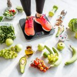 woman weighing on the scales with healthy foods around