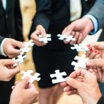 People assembling a jigsaw puzzle