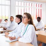 medical students sitting at desk in classroom during lecture