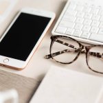 gold iPhone 7 beside black and brown framed eyeglasses