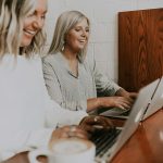 two women using laptops