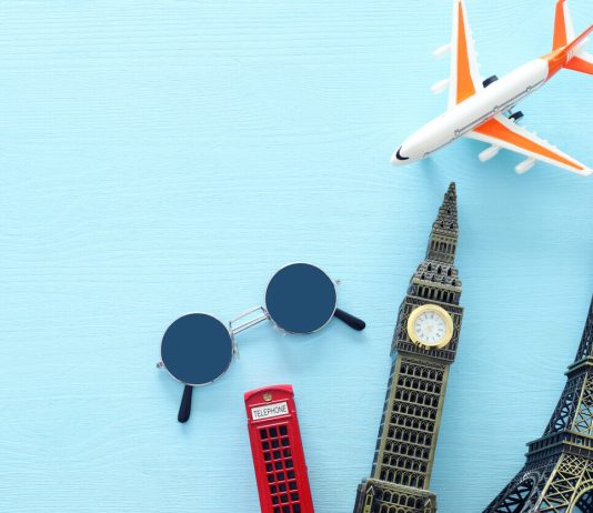 Top view photo of traveling concept with accessories and world symbols over blue background