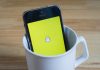 smartphone with snapchat logo in a mug