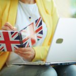 Female taking down notes in a UK flag notebook