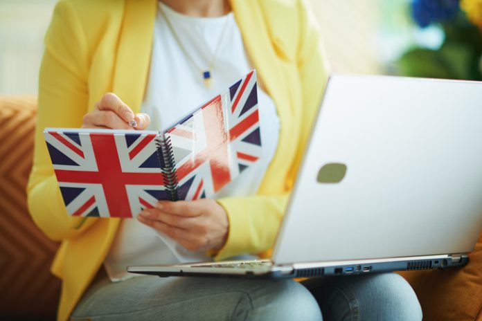 Female taking down notes in a UK flag notebook