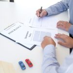 Businessman holding insurance policy for vehicle