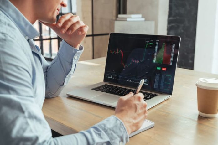 Businessman looking at live trading on computer