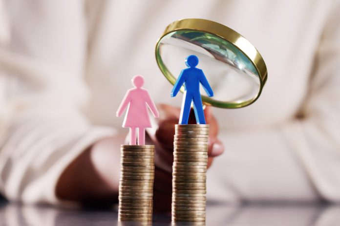 Coin stacks with gender symbol and magnifying glass