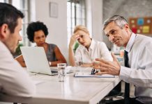 Angry businessman discussing with colleague