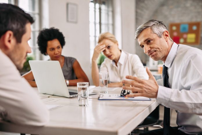 Angry businessman discussing with colleague