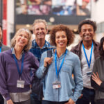 Portrait Of Group Of Smiling Mature Students Standing In College Hall