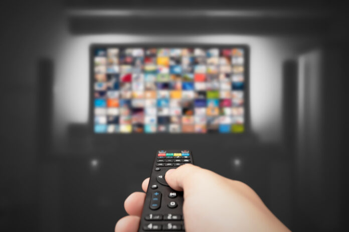 Hand holding remote control for TV