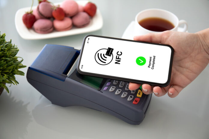 Female hands phone pay wireless technology nfc via pos terminal