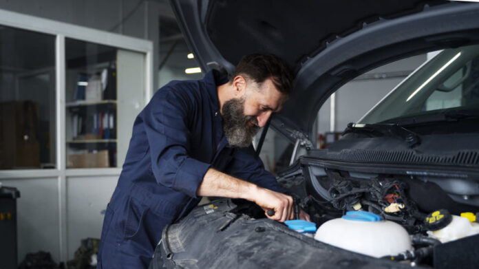 Male mechanic working on car in the auto repair shop