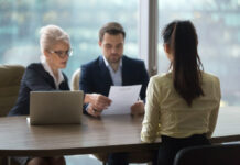 Back view of female candidate apply for position, interview in modern office