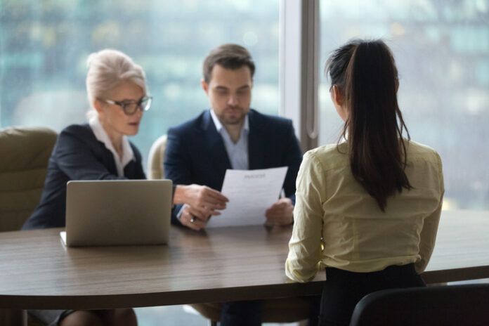 Back view of female candidate apply for position, interview in modern office