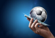 Smartphone in hand with a 3D soccer ball on a blue background