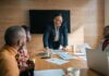 Businessman standing over boardroom table in front of african coworkers during a corporate meeting