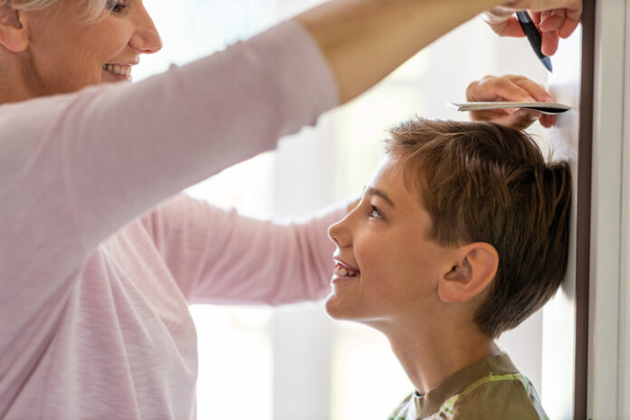 Mother measuring son's height