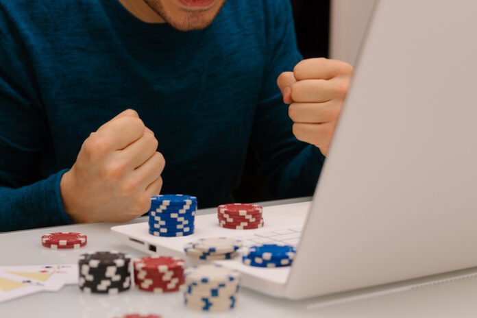 Gamer man playing with his laptop from home to casino games