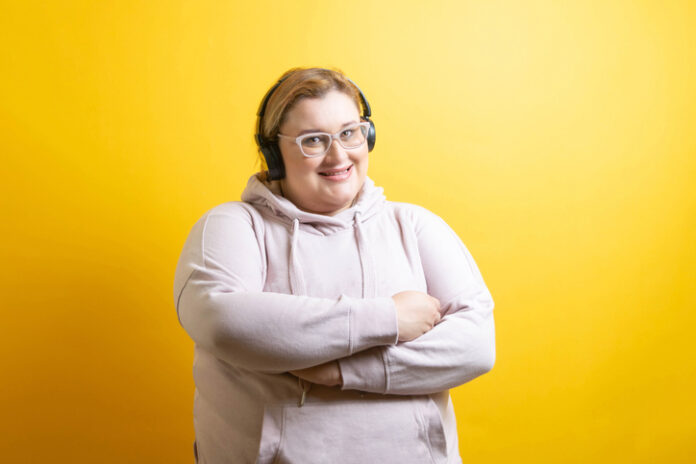 Portrait of sporty caucasian fat woman with headphones