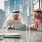 Two Successful Emirati Businessmen in White Traditional Kandura Sitting in Office Meeting