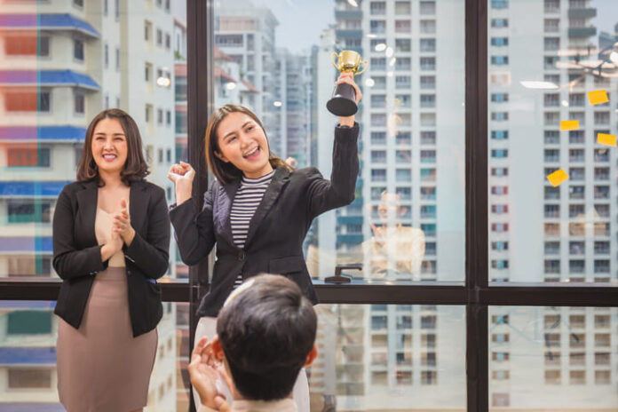 Business woman holding award trophy