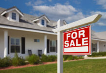 For Sale Real Estate Sign in Front of New House.