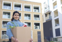 College Student Outdoors Moving Into Campus Room Carrying Box