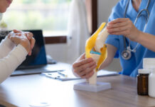 Female doctor who is explaining the treatment method of the knee joint to the woman patient