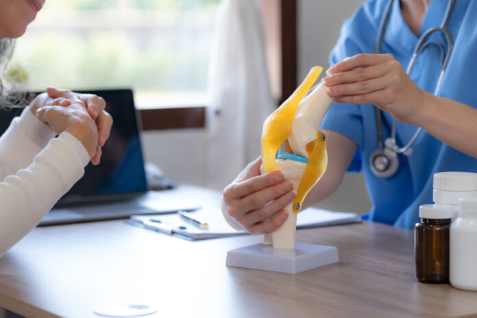 Female doctor who is explaining the treatment method of the knee joint to the woman patient