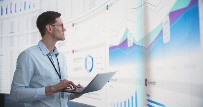 Caucasian Male Business Analyst Holding Laptop Computer