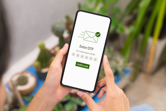 Hand using smartphone and mobile OTP secure verification