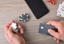 Casino game player accessing payment card to make virtual bets