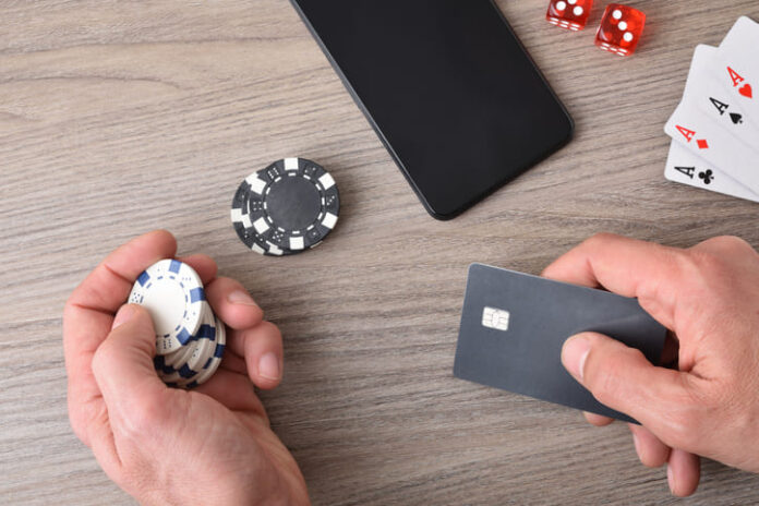 Casino game player accessing payment card to make virtual bets