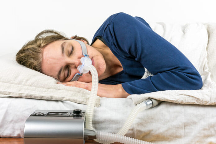 Woman sleeping on her side with CPAP machine