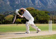 Full length of cricketer playing on field