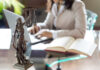 Statue of Justice with scales and lawyer working on a laptop