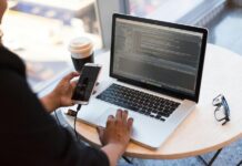 Person Holding Smartphone while using Laptop