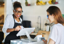 Waitress swiping customers bank card on pos terminal at restaurant